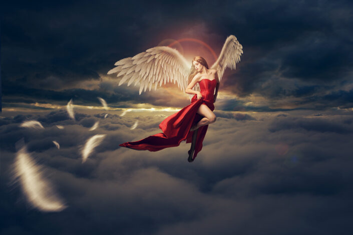 surreal image of woman with wings in the clouds